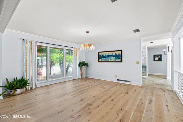 unfurnished living room featuring a chandelier, crown molding, and light hardwood / wood-style flooring