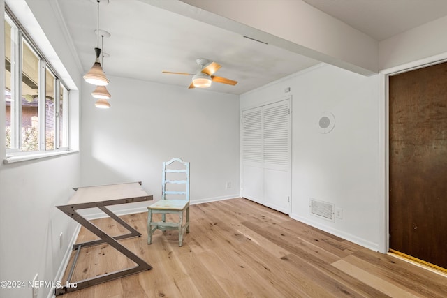 interior space with a ceiling fan, baseboards, visible vents, and wood finished floors