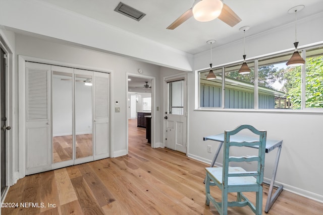 living area featuring light hardwood / wood-style flooring, ceiling fan, and ornamental molding