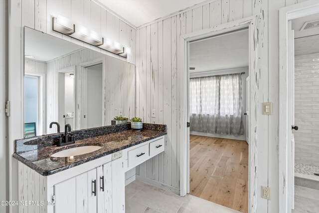 bathroom featuring crown molding, vanity, plenty of natural light, and wood-type flooring