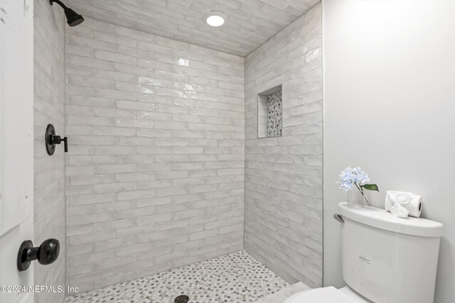 bathroom with tiled shower and toilet