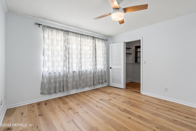 empty room featuring ceiling fan, ornamental molding, wood finished floors, and baseboards