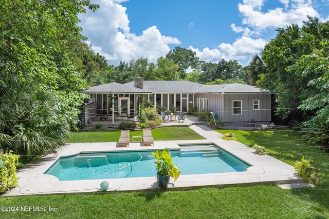 rear view of house with a lawn and a patio