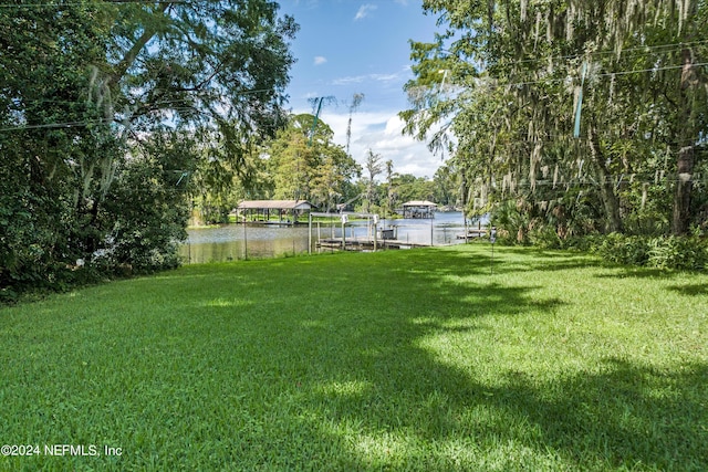 view of yard featuring a dock and a water view