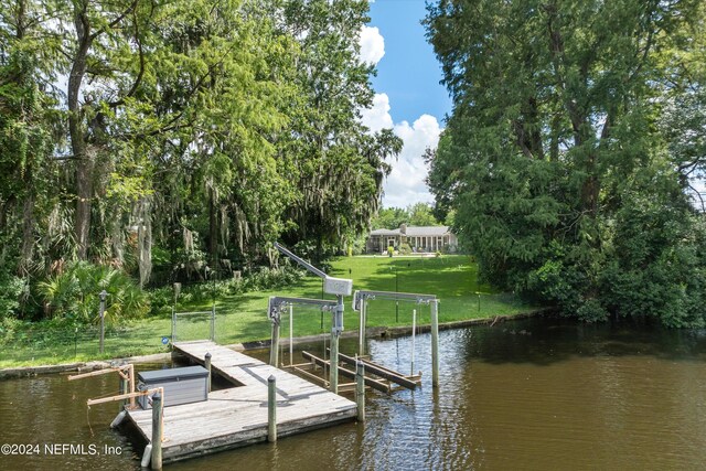 dock area with a lawn and a water view