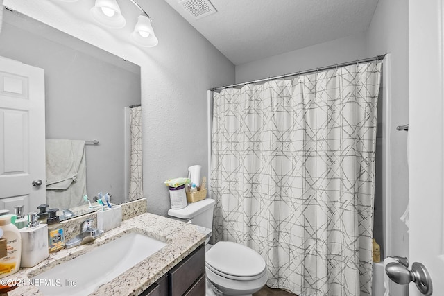 bathroom featuring vanity, toilet, and walk in shower