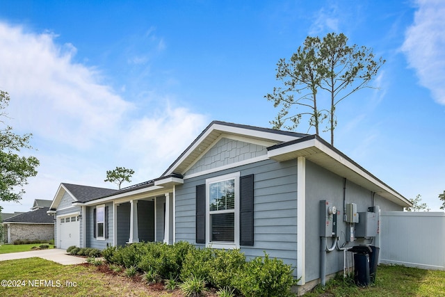 view of side of home featuring a garage, fence, and concrete driveway