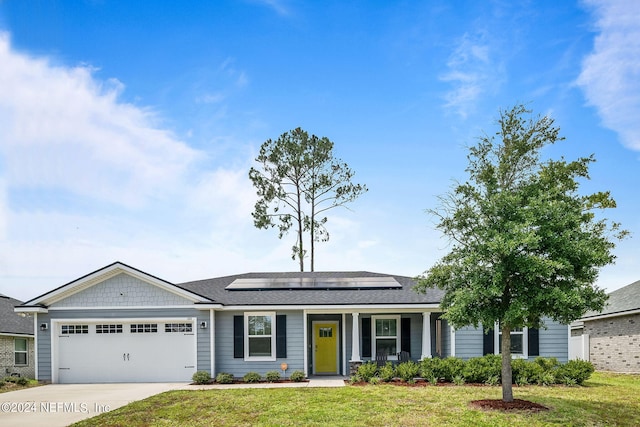 single story home with a garage, a front lawn, and solar panels