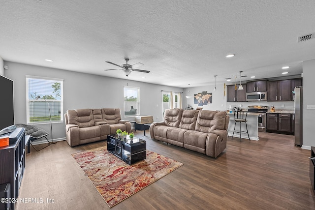 living room featuring a textured ceiling, ceiling fan, and hardwood / wood-style floors