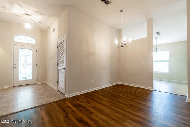 entrance foyer featuring plenty of natural light, wood-type flooring, and a chandelier