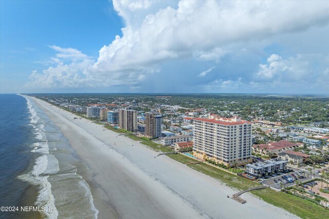 birds eye view of property featuring a water view and a beach view