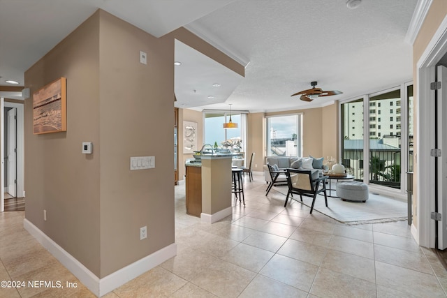 interior space featuring light tile patterned floors, baseboards, an island with sink, a breakfast bar area, and open floor plan