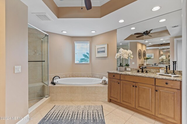 bathroom with tile patterned flooring, vanity, ceiling fan, a tray ceiling, and shower with separate bathtub