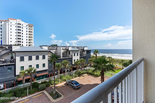 balcony with a water view and a view of the beach