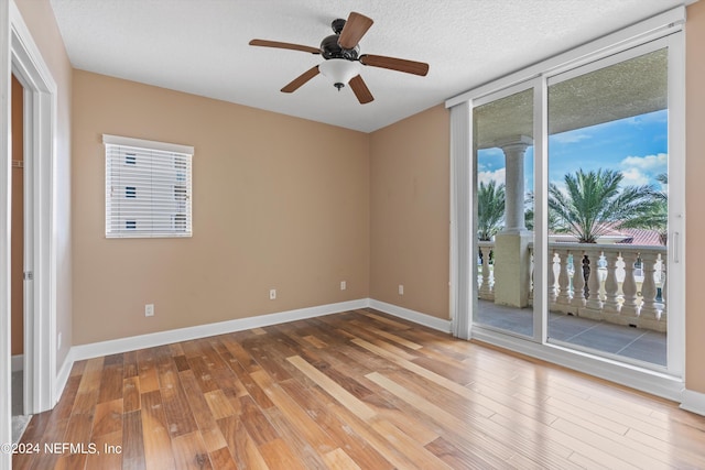 unfurnished room featuring a ceiling fan, a textured ceiling, baseboards, and wood finished floors