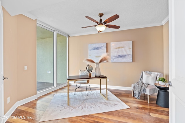 office with crown molding, ceiling fan, a textured ceiling, wood finished floors, and baseboards