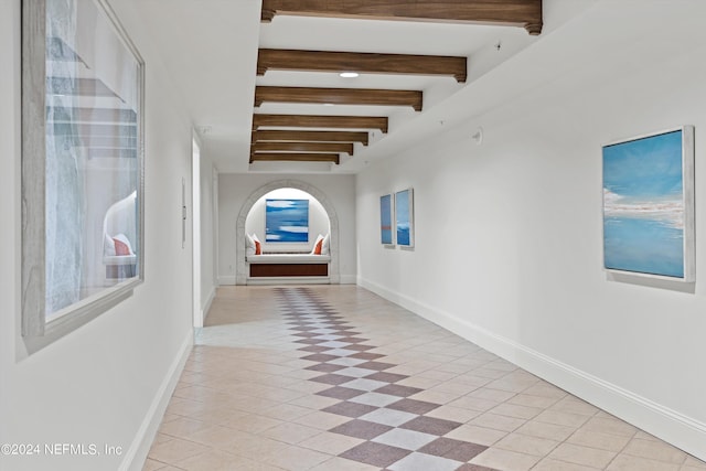 hall featuring beamed ceiling and light tile patterned flooring