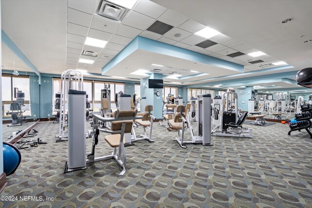 exercise room with a drop ceiling and carpet