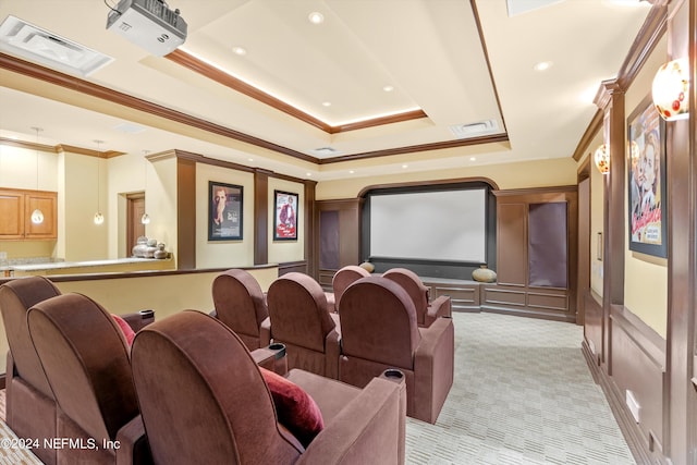 home theater room featuring ornamental molding, a raised ceiling, visible vents, and light colored carpet