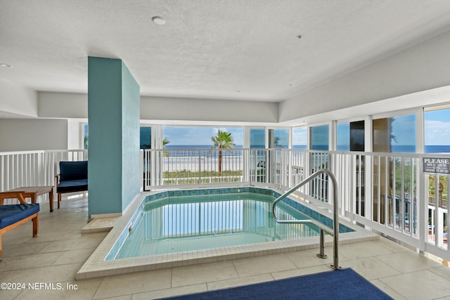 view of pool with a water view and an indoor hot tub