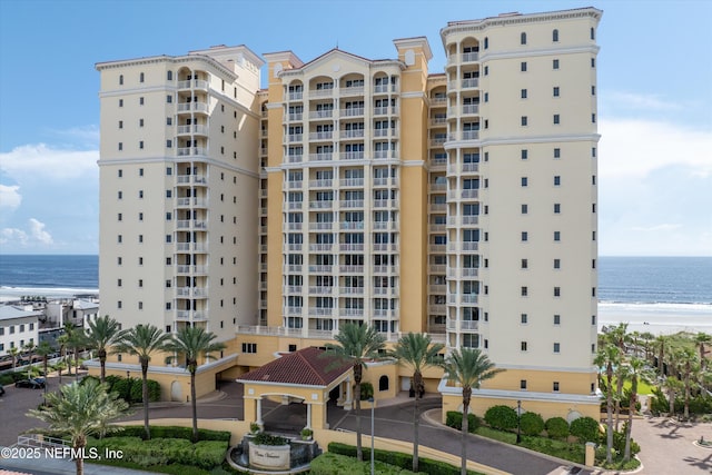 view of building exterior featuring a beach view and a water view