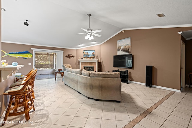 tiled living room with a tile fireplace, lofted ceiling, ornamental molding, and ceiling fan