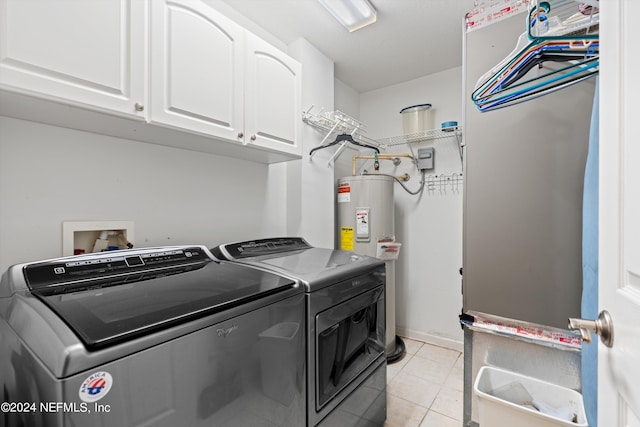 washroom featuring cabinets, water heater, light tile patterned flooring, and washer and clothes dryer