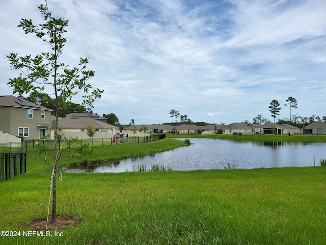 property view of water featuring fence and a residential view