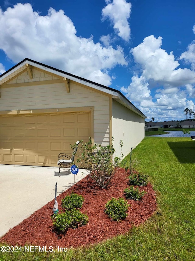 exterior space with a yard, driveway, and an attached garage