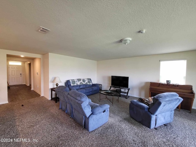 living room featuring dark colored carpet, visible vents, a textured ceiling, and baseboards