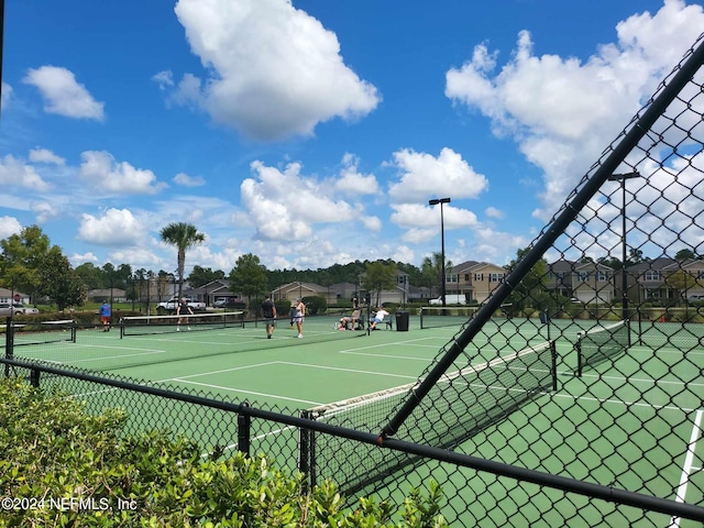 view of tennis court featuring fence