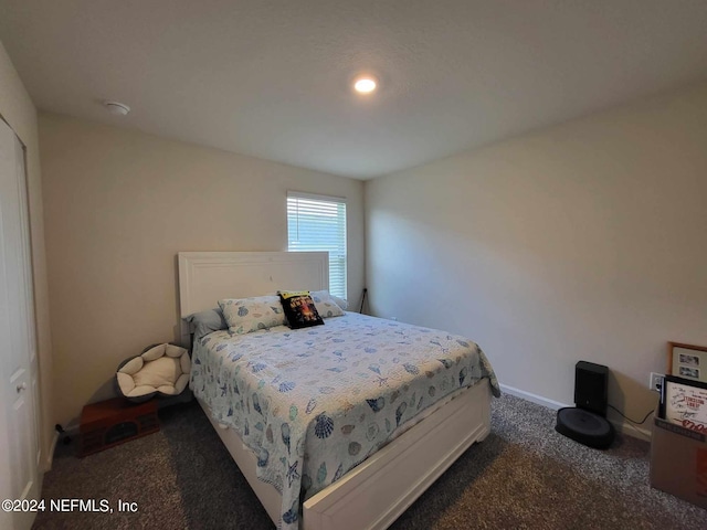 bedroom with dark carpet and baseboards