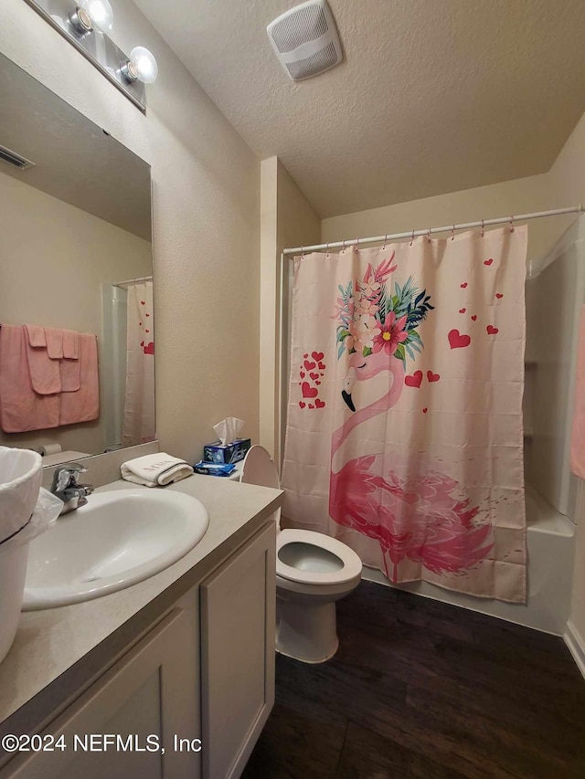 full bathroom featuring toilet, vanity, a textured ceiling, wood-type flooring, and shower / bath combo