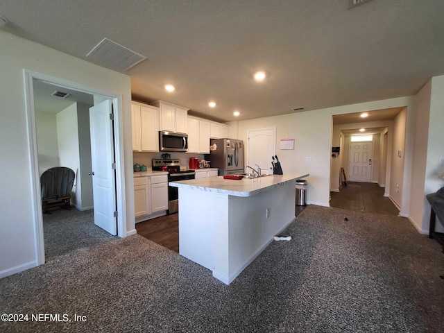 kitchen featuring a kitchen island with sink, a sink, white cabinetry, light countertops, and appliances with stainless steel finishes