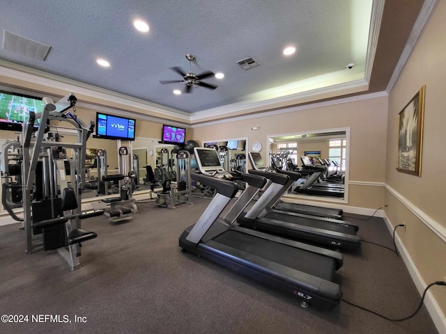 workout area featuring a textured ceiling, crown molding, ceiling fan, and a tray ceiling