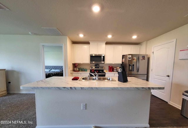 kitchen featuring white cabinets, stainless steel appliances, sink, dark wood-type flooring, and a center island with sink