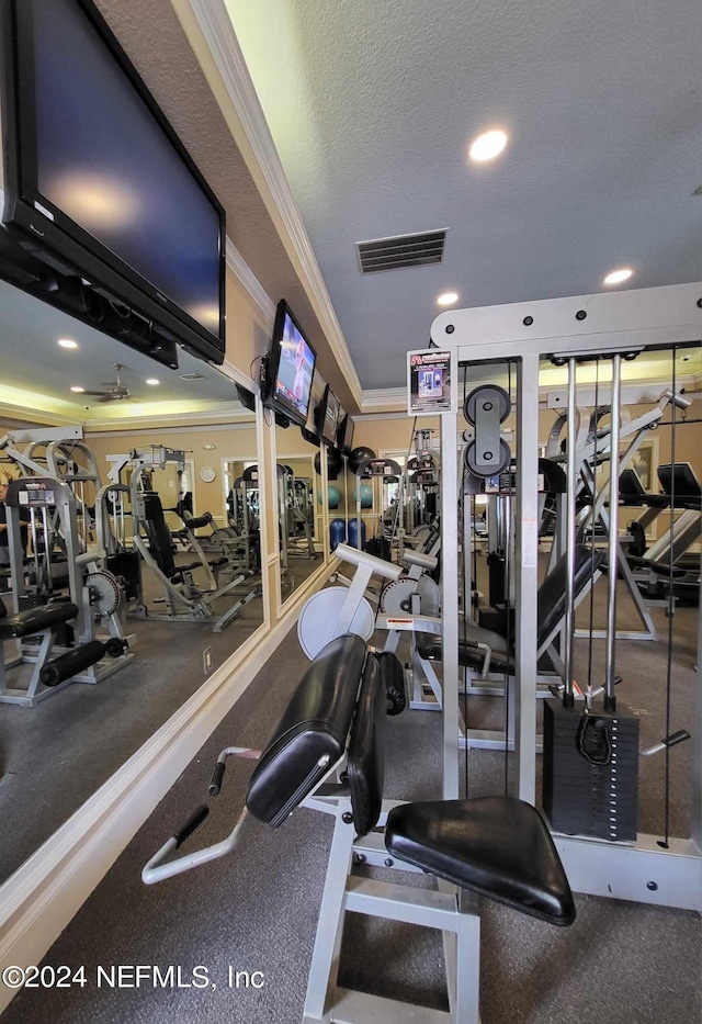 gym with a textured ceiling, recessed lighting, visible vents, and crown molding