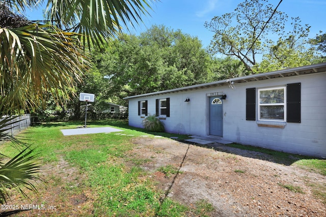 exterior space featuring fence, concrete block siding, a yard, and a patio area