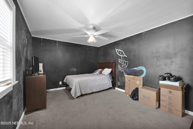 carpeted bedroom with ceiling fan and baseboards