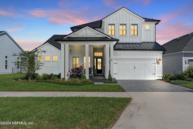 modern inspired farmhouse featuring a yard and a garage