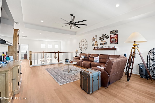 living room featuring ceiling fan, light wood-type flooring, and decorative columns