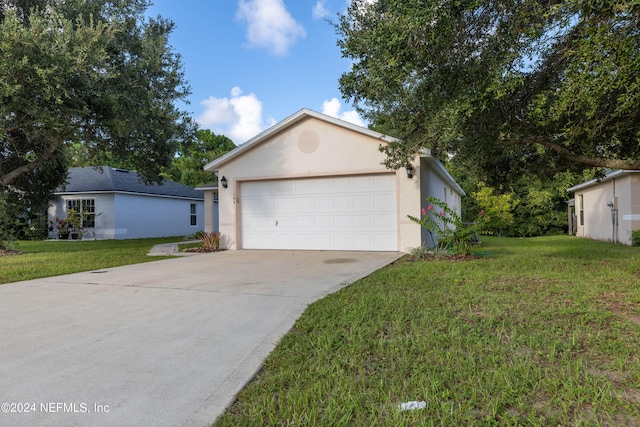 view of front of home with a front yard and a garage