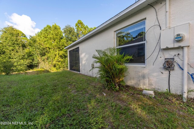 view of side of home with a yard