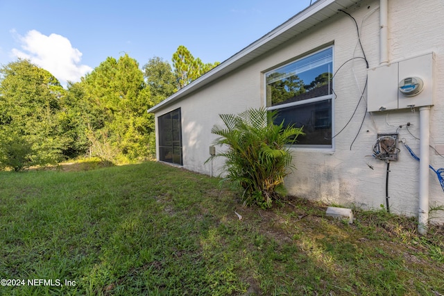 view of side of property featuring a yard and stucco siding