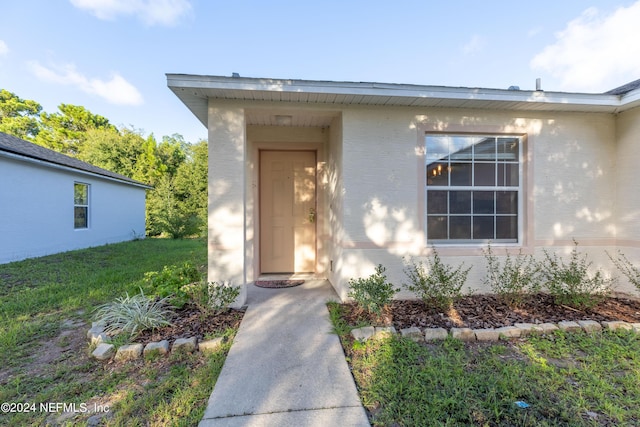 property entrance with a yard