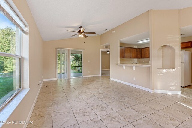 unfurnished living room featuring ceiling fan and vaulted ceiling