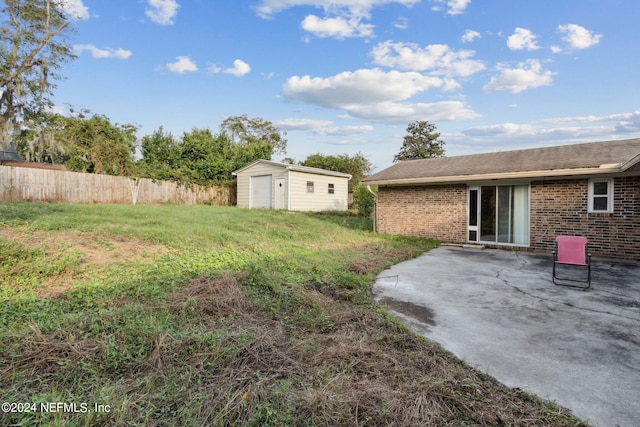 view of yard with a patio and a storage unit