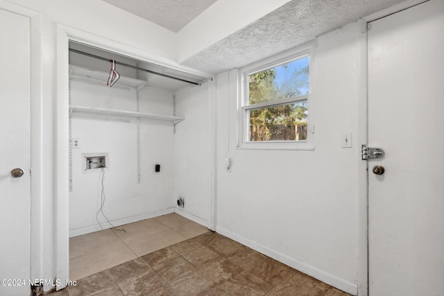 washroom with a textured ceiling, light tile patterned floors, electric dryer hookup, and washer hookup