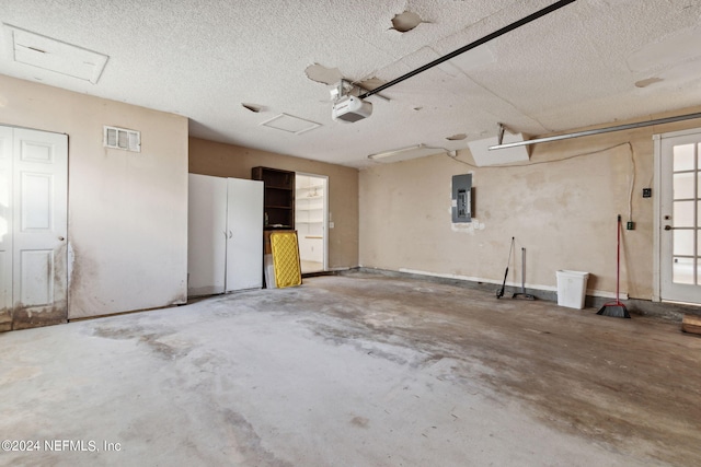 garage with a garage door opener and electric panel