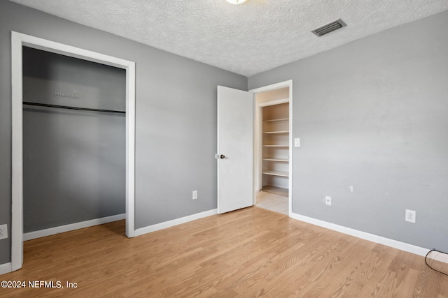 unfurnished bedroom featuring light wood-type flooring and a textured ceiling